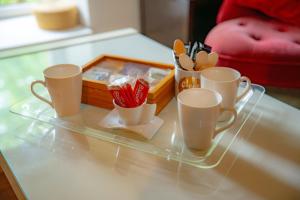 a tray with cups and a box on a table at La Suite de Richarville in Richarville
