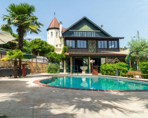 a house with a swimming pool in front of a house at La Maison cachée du PAVILLON BELLEVUE in Belley