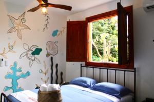 a bedroom with a bed with blue sheets and a window at Finca Ki' - Eco Farm Stay Bed & Breakfast - El Yunque Region in Naguabo