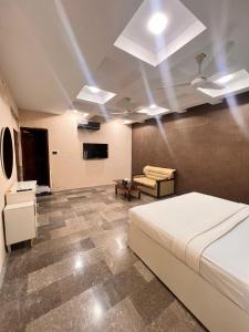 a bedroom with a bed and a couch in it at Royal Confort Inn in Karachi
