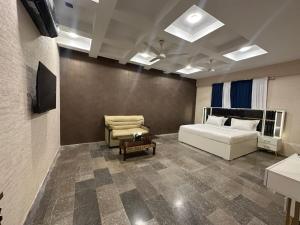 a bedroom with a bed and a couch and a chair at Royal Confort Inn in Karachi