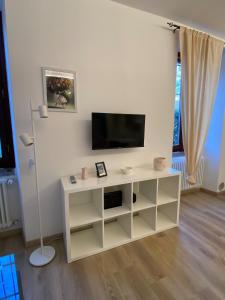 a living room with a tv and a white cabinet at Casa MELISSA LIMONCELLA , free parking-self check in in Tavernerio