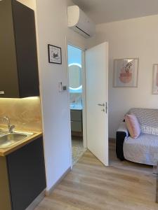 a bathroom with a sink and a bed in a room at Casa MELISSA LIMONCELLA , free parking-self check in in Tavernerio