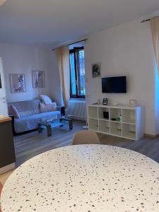 a living room with a table and a couch at Casa MELISSA LIMONCELLA , free parking-self check in in Tavernerio +10 photos