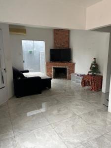 a living room with a fireplace and a christmas tree at Casa Gui in São Gabriel