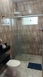a bathroom with a toilet and a glass shower at Casa Gui in São Gabriel