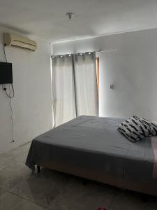 a bedroom with a bed and a window at Casa Gui in São Gabriel