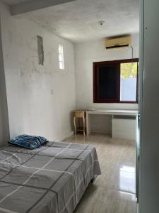 a white room with a bed and a television at Casa Gui in São Gabriel
