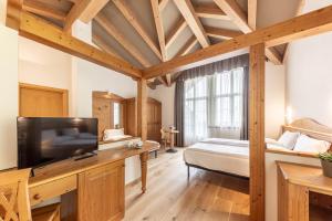 a bedroom with a bed and a tv in a room at WHITE MOSS GARNì in Transacqua