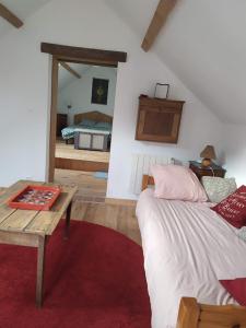 a bedroom with a bed and a table and a mirror at Le refuge in Montabon