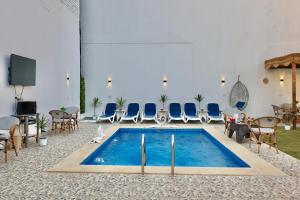 a pool in a room with chairs and a table at White Gorf Hotel in Luxor