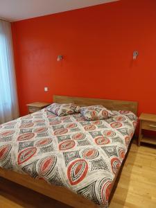 a bed in a bedroom with an orange wall at Gîte d'ammerschwihr in Ammerschwihr