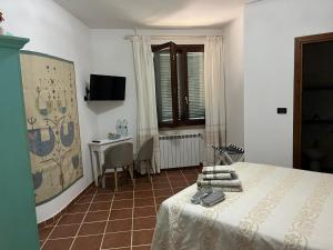 a bedroom with a bed and a table and a desk at Domo Rosada in Ottava Sassari