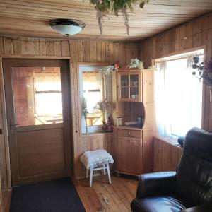 a living room with a door and a chair at Sauna house in Daugavpils