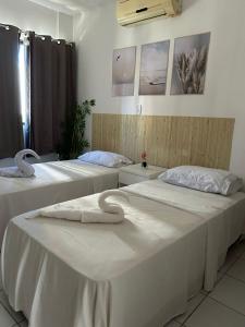 a room with two beds with towels on them at Pousada Mar de Maceió in Maceió