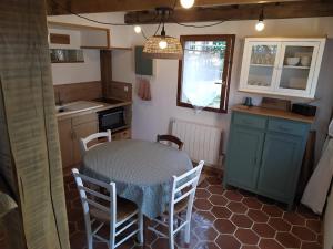 a kitchen with a table and chairs in a kitchen at Le refuge in Montabon