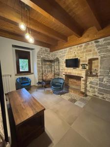 a living room with a stone wall with a tv at Lo Shangrilá B&B in Borrello