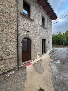 a stone building with a brown door on it at Lo Shangrilá B&B in Borrello