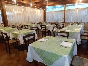 a room with tables and chairs with green tablecloths at I Giardini Di Eidos in Sant'Agata de' Goti