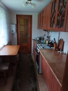 a kitchen with wooden cabinets and a stove top oven at Ольга in Ogrody +2 photos