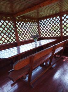 a wooden bench in a room with a table at Ольга in Ogrody