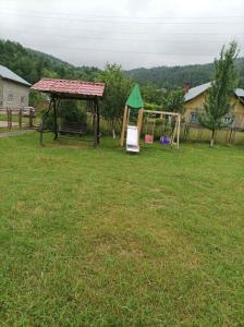 a gazebo and a swing set in a yard at Ольга in Ogrody