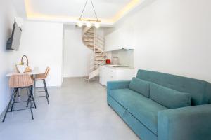 a living room with a blue couch and a table at Sirens Resort in Agioi Apostoli