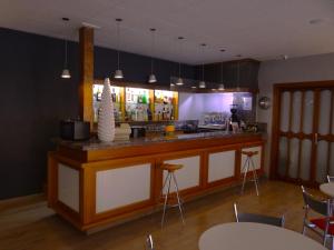 Eine Küche mit Theke und Bar mit Hockern in der Unterkunft Hotel Sol-Park in Sant Julià de Lòria