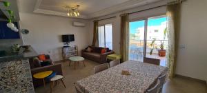 a living room with a table and a living room with a view at Excellent Appartement S plus 3 in Kelibia