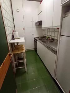 a small kitchen with green floors and a refrigerator at Casetta mia, Pian de Valli in Terminillo