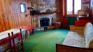 a room with a fireplace and a bed and a couch at Casetta mia, Pian de Valli in Terminillo