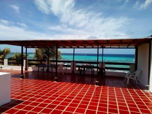 a patio with a view of the ocean on a beach at Posada Doña Carmen in El Roque