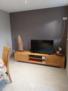 a flat screen tv sitting on top of a wooden entertainment center at Gîte d'ammerschwihr in Ammerschwihr