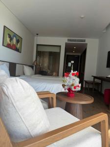 a hotel room with a bed and a table and chairs at Apec Mandala Chambay - Dimond Hotel in Ấp Thiẹn Ái