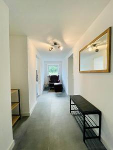 a living room with a mirror and a couch at Lichtdurchflutetes Souterrain Apartment in Schapen in Braunschweig