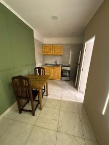 a kitchen with a wooden table and chairs in it at Deptos Helen in Termas de Río Hondo +3 photos