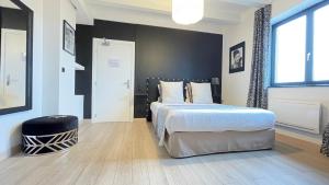 a bedroom with a bed and a black wall at Hôtel Restaurant Verger des Châteaux, Route des vins Haut-Koenigsbourg in Dieffenthal