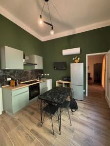 a kitchen with green walls and a table with chairs at SVR Green in Bronte