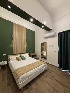 a bedroom with a large bed and a green wall at SVR Green in Bronte