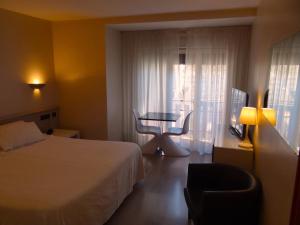 ein Hotelzimmer mit einem Bett, einem Tisch und einem Fenster in der Unterkunft Hotel Sol-Park in Sant Julià de Lòria + 82 Fotos