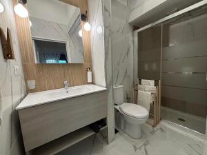 a bathroom with a sink and a toilet and a mirror at SVR Green in Bronte