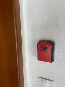 a red button on the side of a door at BLUE PANORAMA DIAMOND with Amazing Sea View in Makri