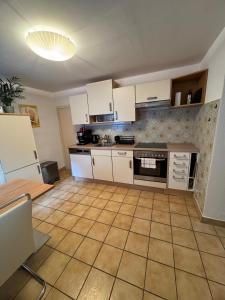a kitchen with white cabinets and a tile floor at Haus Anna in Köttwein