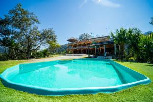 a large swimming pool in front of a house at El Mirador de Lanquin in Lanquín