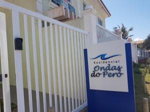 a sign in front of a house with aaway dog pee at Residencial a Beira Mar Pero in Cabo Frio