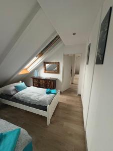 a attic bedroom with a bed and a staircase at Apartament Loft DeLuxe Koszalin in Koszalin