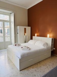 a bedroom with a large white bed with white sheets at Diaz Central Rooms in Salerno