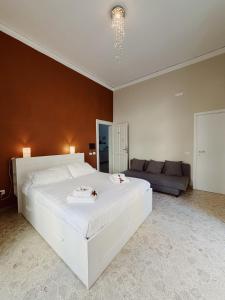 a bedroom with a large white bed and a couch at Diaz Central Rooms in Salerno +20 photos