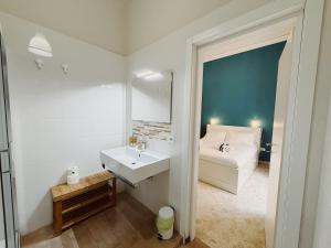 a bathroom with a white sink and a bed at Diaz Central Rooms in Salerno