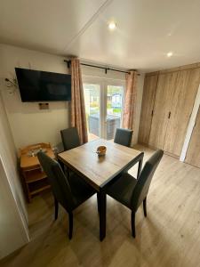 a dining room with a wooden table and chairs at Chalet Levy in Lauwersoog